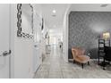 Bright hallway with tile flooring, decorative wallpaper, and natural light streaming through the open-concept layout at 11054 Hanlon Terrace Aly, Winter Garden, FL 34787