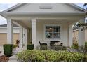 Inviting porch with comfortable wicker seating area enhanced by lush landscaping at 12679 Calderdale Ave, Windermere, FL 34786