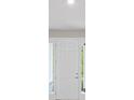 Bright entryway with a white front door and sidelights at 136 N James Pl, Groveland, FL 34736