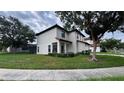 Exterior view of a two-story home featuring stucco walls, red tile roof, and landscaped front yard at 16631 Lazy Breeze Loop, Clermont, FL 34714