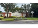 Community entrance sign for High Grove featuring manicured landscaping and vibrant plants at 16631 Lazy Breeze Loop, Clermont, FL 34714
