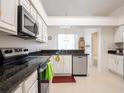 Bright kitchen featuring white cabinetry, granite countertops, stainless steel appliances, and a stainless dishwasher at 1672 Canoe Creek Rd, Oviedo, FL 32766