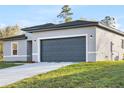Exterior view of a modern gray home featuring a spacious driveway and attached garage at 178 Marion Oaks Ln, Ocala, FL 34473