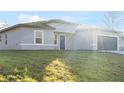 Well-maintained one-story home with a gray facade, fresh green lawn, and an attached garage at 178 Marion Oaks Ln, Ocala, FL 34473