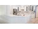 Bright kitchen with stainless steel refrigerator, white cabinets, and expansive marble countertop at 19951 Quinlan St, Orlando, FL 32833