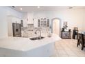 Bright kitchen with stainless steel refrigerator, white cabinets, and expansive marble countertop island at 19951 Quinlan St, Orlando, FL 32833