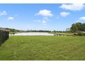 Spacious backyard with lush green grass and beautiful water views at 2400 Addison Creek Dr, Kissimmee, FL 34758