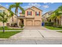 Charming two-story home featuring a well-maintained lawn, mature palm trees, and a two-car garage at 2777 Monticello Way, Kissimmee, FL 34741