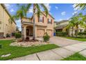 Charming two-story home featuring a well-maintained lawn, mature palm trees, and a two-car garage at 2777 Monticello Way, Kissimmee, FL 34741