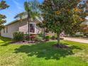 Attractive home exterior with mature trees, manicured lawn and stone accents at 3744 Quaint Ln, Clermont, FL 34711