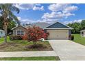 Charming single-story home with stone accents, a two-car garage and flowering bushes at 382 Lake St, Umatilla, FL 32784
