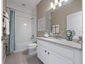 Bright bathroom featuring a shower/tub combo with a decorative curtain, and a vanity with modern finishes at 4413 Lions Gate Ave, Clermont, FL 34711
