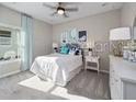 Charming bedroom featuring a ceiling fan, large windows and a comfortable bed with stylish decor at 4413 Lions Gate Ave, Clermont, FL 34711