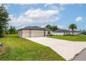 A single-story home with a manicured lawn, driveway, and a two-car garage with neutral paint at 4780 Sw 129Th Pl, Ocala, FL 34473