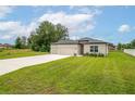 A single-story home with a manicured lawn, driveway, and a two-car garage in a landscaped yard at 4780 Sw 129Th Pl, Ocala, FL 34473