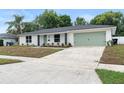 Beautiful one-story home featuring a well-maintained lawn and charming curb appeal, including a green garage door at 4858 Brenda Dr, Orlando, FL 32812