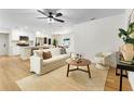 Bright, open-concept living room features stylish furnishings, and flows into the modern white kitchen beyond at 4858 Brenda Dr, Orlando, FL 32812