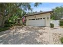 Spacious two-car garage with a paved driveway and beautiful landscaping at 489 Penny Ln, Maitland, FL 32751