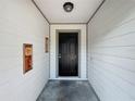 Inviting front porch with a black door, neutral walls, and a decorative wall art at 4942 Eden View Ct, Orlando, FL 32810
