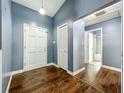 Hallway with wood floors, blue walls, closet space, and access to the bathroom at 4942 Eden View Ct, Orlando, FL 32810