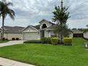 Beautiful home with lush green lawn, palm tree, and manicured shrubbery in the front yard at 541 Arena Dr, Davenport, FL 33837