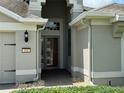 A well-lit home entrance featuring a storm door, brick pathway, and stylish exterior finishes at 541 Arena Dr, Davenport, FL 33837