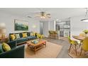 Open-concept living area featuring modern furniture, a ceiling fan, and seamless access to the kitchen at 5436 E Michigan St # 7, Orlando, FL 32812