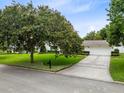 Well-maintained home featuring a spacious driveway, mature landscaping, and an attached two-car garage at 609 Langholm Dr, Winter Park, FL 32789