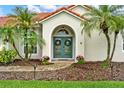 Inviting front entrance with a teal double door, arched entryway and manicured landscaping at 6321 Clearmeadow Ct, Windermere, FL 34786