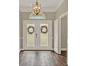 Welcoming foyer with double doors, decorative lighting, and hardwood flooring. Ready to be customized at 6321 Clearmeadow Ct, Windermere, FL 34786