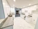 Bright kitchen featuring white cabinets, granite countertops, stainless steel appliances, and new flooring at 6849 Palomino Dr, Lakeland, FL 33811