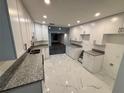 Renovated kitchen with white cabinetry, granite countertops, and modern fixtures at 6849 Palomino Dr, Lakeland, FL 33811