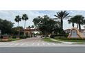 Community entrance with decorative fountain and landscaped median at 720 Las Fuentes Dr, Kissimmee, FL 34746