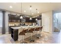 Modern kitchen with dark cabinets, stainless steel appliances, granite countertops, and a breakfast bar with seating at 8801 Corcovado Dr, Kissimmee, FL 34747