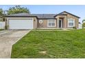 Charming single-story home with a well-maintained lawn and attached two-car garage, showcasing curb appeal at 112 Lake Butler Ave, Haines City, FL 33844