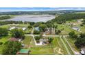 Expansive aerial view of a private estate with a tennis court and lake at 12434 Sullivan Rd, Clermont, FL 34715