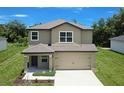 Two-story home showcasing a neutral exterior, covered porch, and attached two-car garage at 1303 Congo Ct, Kissimmee, FL 34759
