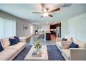 Open-concept living room featuring hardwood floors, modern decor, and a view of the kitchen at 1303 Congo Ct, Kissimmee, FL 34759