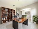 Elegant office space with built-in bookshelves, a large executive desk, and neutral decor at 137 Drayton Ave, Davenport, FL 33837