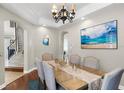 Bright dining room featuring wood floors, chandelier, and serene beach-themed decor at 14038 Bluebird Park Rd, Windermere, FL 34786