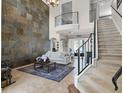 Spacious living room with soaring ceilings, grand staircase, and stylish stone accent wall at 14038 Bluebird Park Rd, Windermere, FL 34786