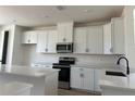 Contemporary kitchen featuring sleek white cabinets and stainless steel appliances at 15095 Grove Lake Dr, Winter Garden, FL 34787