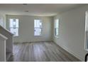 Bright living room featuring hardwood floors, white walls and plenty of natural light at 15107 Grove Lake Dr, Winter Garden, FL 34787