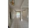Spacious living room with tile flooring, decorative chandelier, and view of the pool area at 1586 Antoinette Ct, Oviedo, FL 32765
