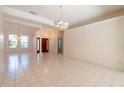 Spacious living room features tile flooring, classic chandelier, and a view of the front entrance at 1586 Antoinette Ct, Oviedo, FL 32765