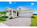 Inviting single-Gathering home with lush landscaping, a paved driveway, and a two-car garage at 1596 Contentment Loop, Kissimmee, FL 34744