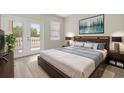 Comfortable main bedroom featuring a king bed, balcony access, and stylish decor at 1705 Saint Tropez Ct, Kissimmee, FL 34744