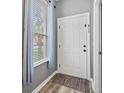 Bright entryway featuring a white door, wood floors, a large window, and modern gray walls at 17516 Blessing Dr, Clermont, FL 34714