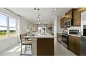 Stylish kitchen featuring stainless steel appliances, a white countertop island, and elegant pendant lighting at 1916 Diamond Head Cir, Lake Hamilton, FL 33851