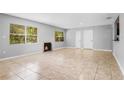 Bright living room with tile floors, a decorative fireplace, and abundant natural light at 1961 Winter Park Rd, Winter Park, FL 32789